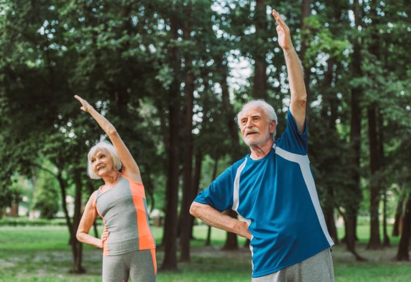 stock-photo-selective-focus-senior-man-exercising-smiling-wife-park